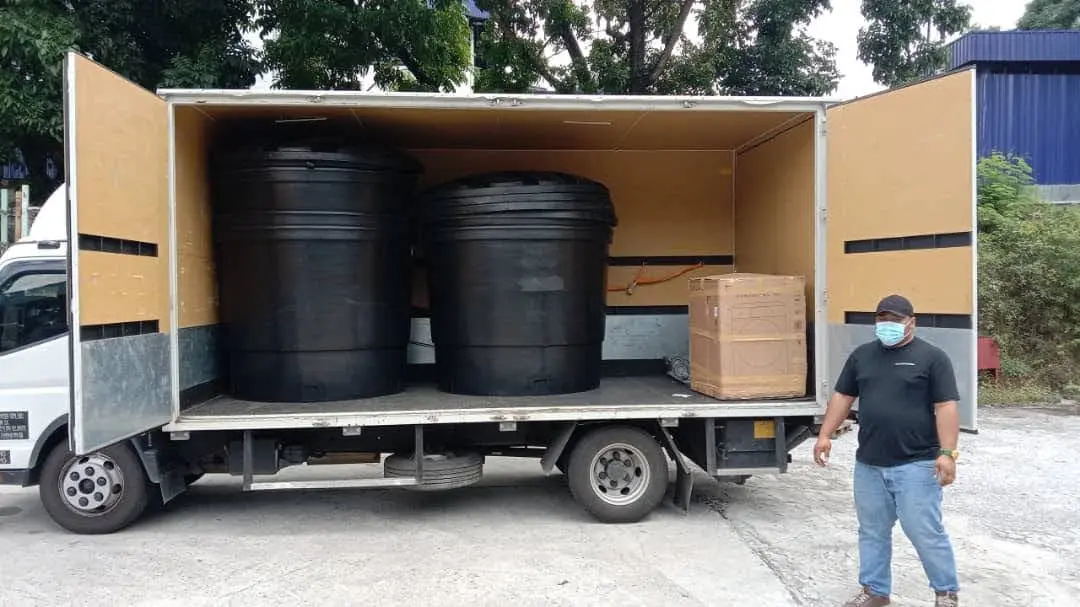 Mileford lorry loaded with large black industrial tanks and a wooden crate, ensuring secure transport.